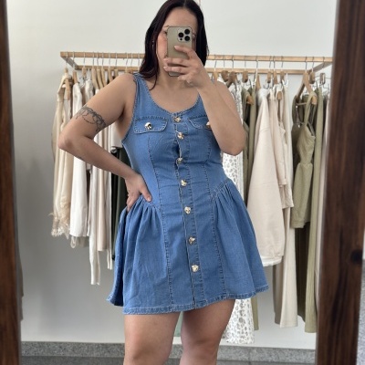 Vestido curto azul de ganga com botões dourados, bolsos no peito e saia rodada