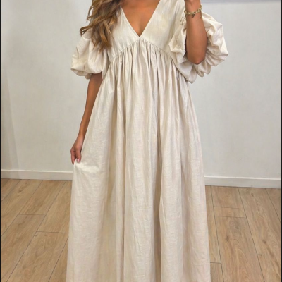 Mulher a usar vestido comprido branco com decote em V e mangas bufantes