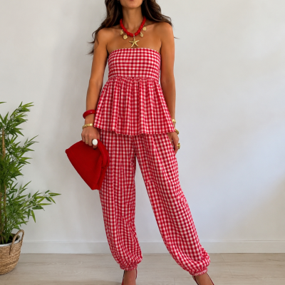 Conjunto xadrez vermelho e branco em mulher com acessórios vermelhos, planta e fundo branco