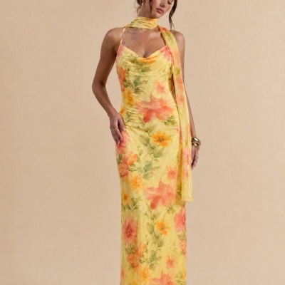 Vestido comprido amarelo com padrão floral em tons de laranja e verde