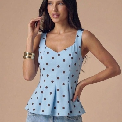 Top azul claro com bolinhas castanhas e calças de ganga por mulher