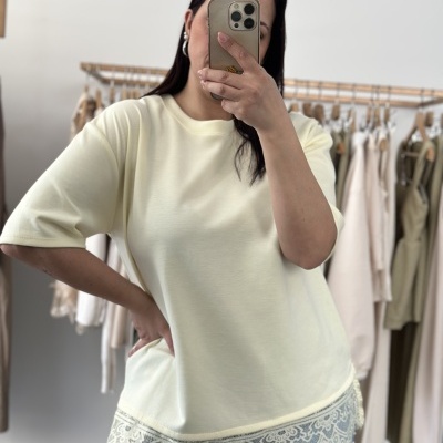 T-shirt feminina amarelo claro com renda e jeans azuis numa loja de roupa