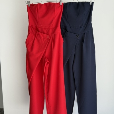 Dois macacões femininos, vermelho e azul escuro, pendurados em cabides.