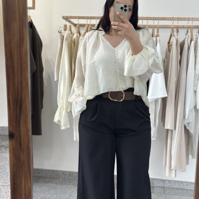 Blusa branca leve e calças pretas largas com cinto castanho