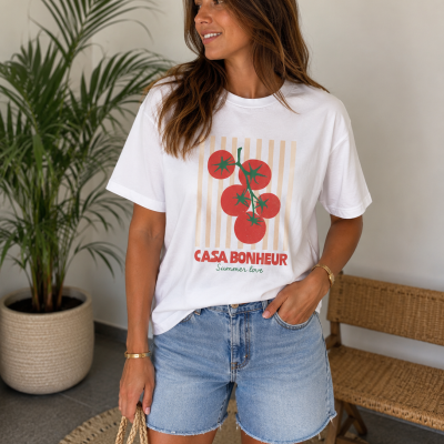 Mulher com t-shirt branca estampada de tomates e calções de ganga azuis