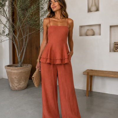 Conjunto feminino terracota de linho com top de alças e calças largas em ambiente minimalista