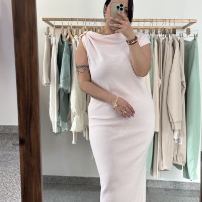 Vestido comprido rosa claro com detalhe dourado no ombro em loja de roupa.