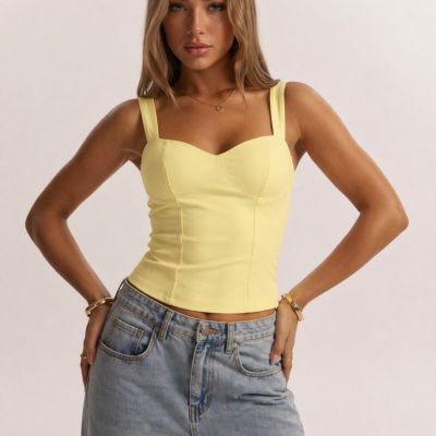 Top amarelo com alças largas e calças de ganga azul claro em fundo branco