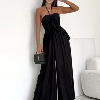 Mulher com macacão preto e óculos de sol brancos segurando bolsa preta YSL
