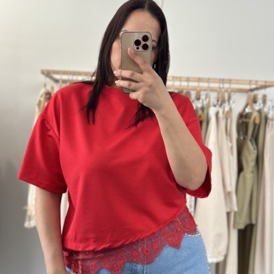 T-shirt vermelha de manga curta com renda vermelha na bainha e jeans azuis claros