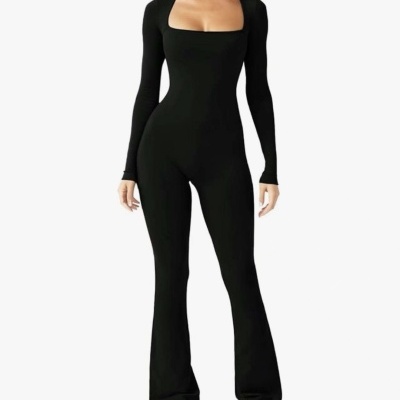 Mulher com macacão preto justo de manga comprida e decote quadrado, pernas flare, fundo branco