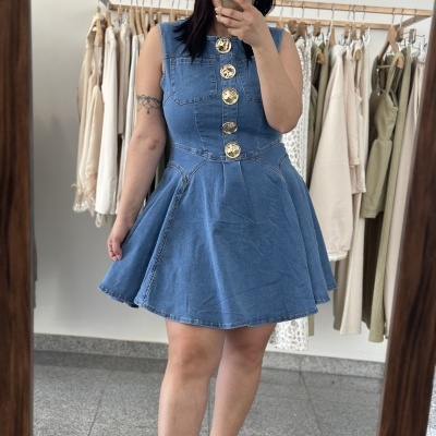 Vestido curto de ganga azul com botões dourados num provador