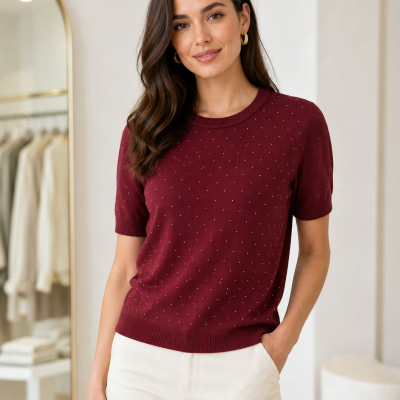 Camisola bordeaux de malha com pontos brancos e calças claras num ambiente interior moderno