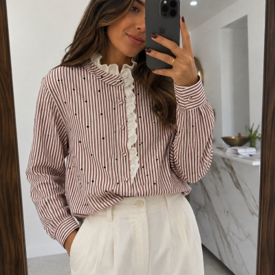 Blusa feminina com riscas vermelhas e bolinhas pretas, gola de renda branca, botões forrados, calças brancas altas.