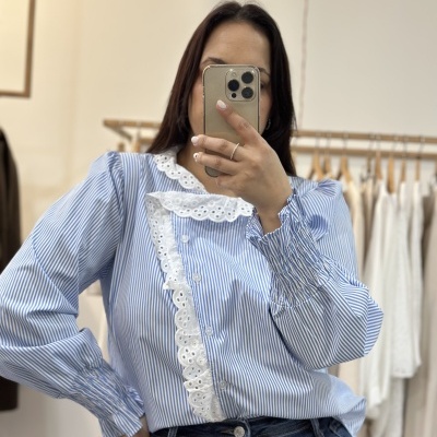 Blusa riscada azul e branca com renda branca e calças de ganga azul-escuro