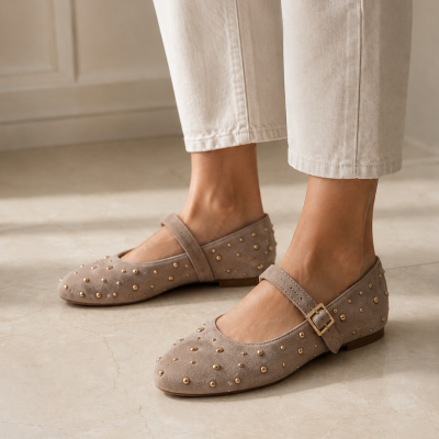 Sapatos Mary Jane bege aveludados com tachas douradas e fivelas.