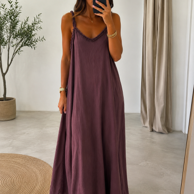 Vestido longo roxo fluido com acabamento frisado, sandálias castanhas, planta em vaso e cortinas claras