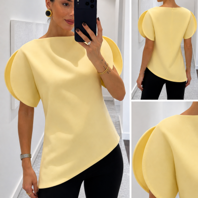 Mulher a usar blusa amarela com mangas volumosas e assimétricas
