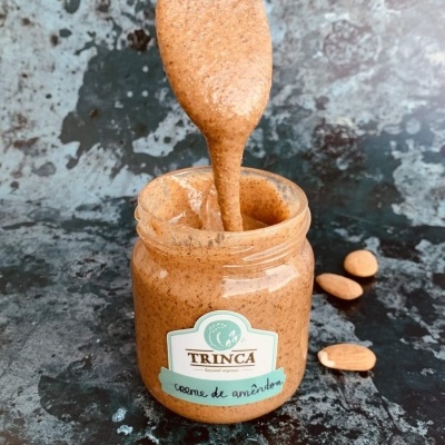 Frasco de creme de amêndoa TRINCA com colher a retirar o creme