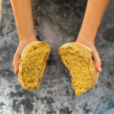 Pão integral partido ao meio com crosta fina e textura densa