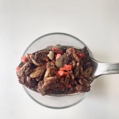 Colher com granola mista colorida em fundo branco