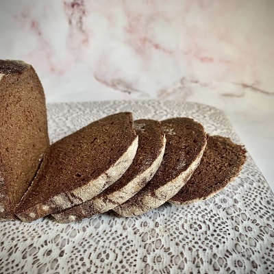 Pão integral em fatias sobre toalha de renda branca