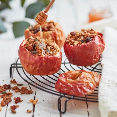 Maçãs assadas recheadas com granola e mel sobre grade metálica e pano branco