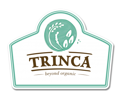 Etiqueta branca com borda verde, círculo verde com folhas e frutos e texto TRINCA beyond organic