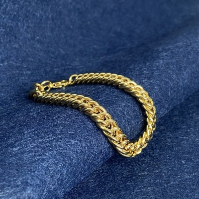 Pulseira dourada sobre tecido azul