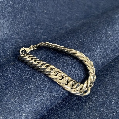 Colar de corrente prateada com dois padrões sobre tecido azul escuro