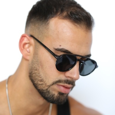 Óculos de sol pretos numa pessoa com cabelo curto e barba