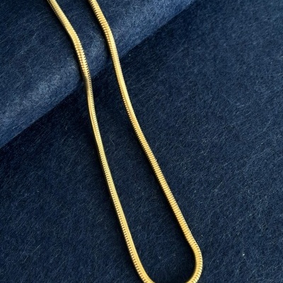 Colar dourado sobre tecido azul