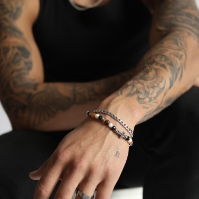 Pulseiras masculinas de metal prateado com anel, em pulso de homem com tatuagens e camisa preta