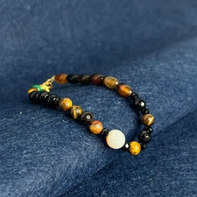 Pulseira de contas de pedras coloridas sobre tecido azul