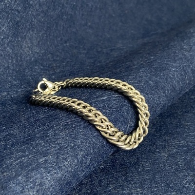 Pulseira prateada sobre tecido azul escuro