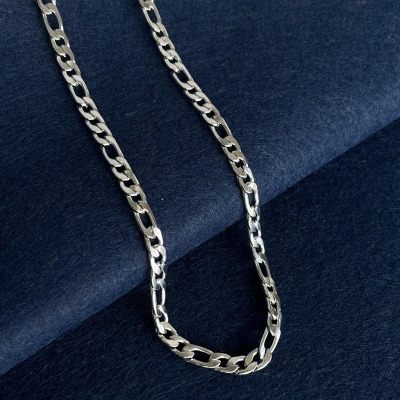 Colar corrente prateado sobre tecido azul escuro