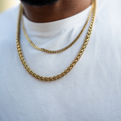 Homem com duas correntes douradas sobre t-shirt branca