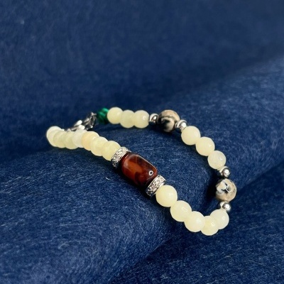 Pulseira com contas creme e detalhe castanho em tecido azul