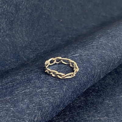 Anel de elos prateado sobre tecido azul escuro