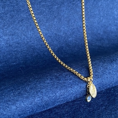 Colar dourado com pendentes sobre tecido azul aveludado