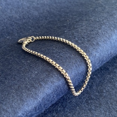 Pulseira metálica prateada sobre tecido azul escuro