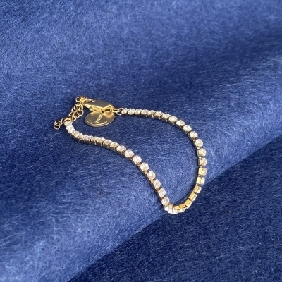 Pulseira dourada com pedras transparentes e pendente redondo