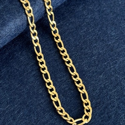 Colar dourado tipo corrente sobre tecido azul escuro