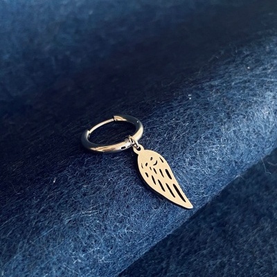 Argola prateada com pendente em forma de asa sobre tecido azul escuro