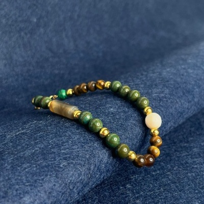 Pulseira colorida com contas redondas sobre tecido azul escuro