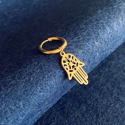 Brinco dourado com pendente em forma de mão Hamsá sobre tecido azul