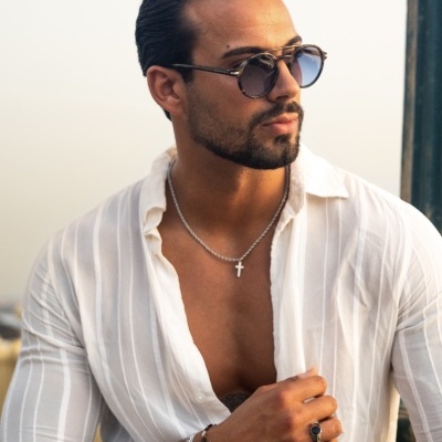 Homem de óculos de sol e camisa branca transparente ao ar livre