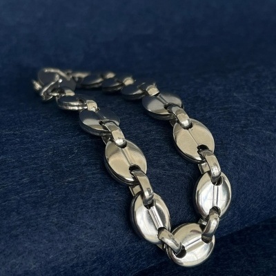 Colar metálico prateado com elos ovais sobre tecido azul escuro