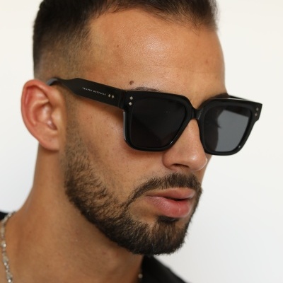 Óculos de sol quadrados pretos com lentes escuras em modelo masculino