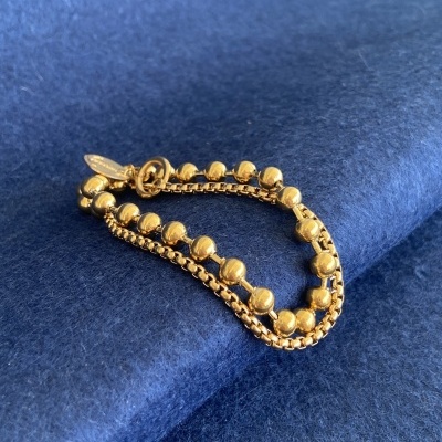 Pulseira dourada sobre tecido azul felpudo